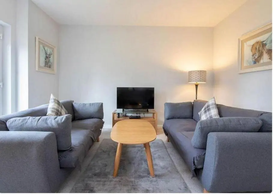 a living room with two couches and a television at 2 Bedroom Hedgefield Apartment 41-Free Parking in Inverness