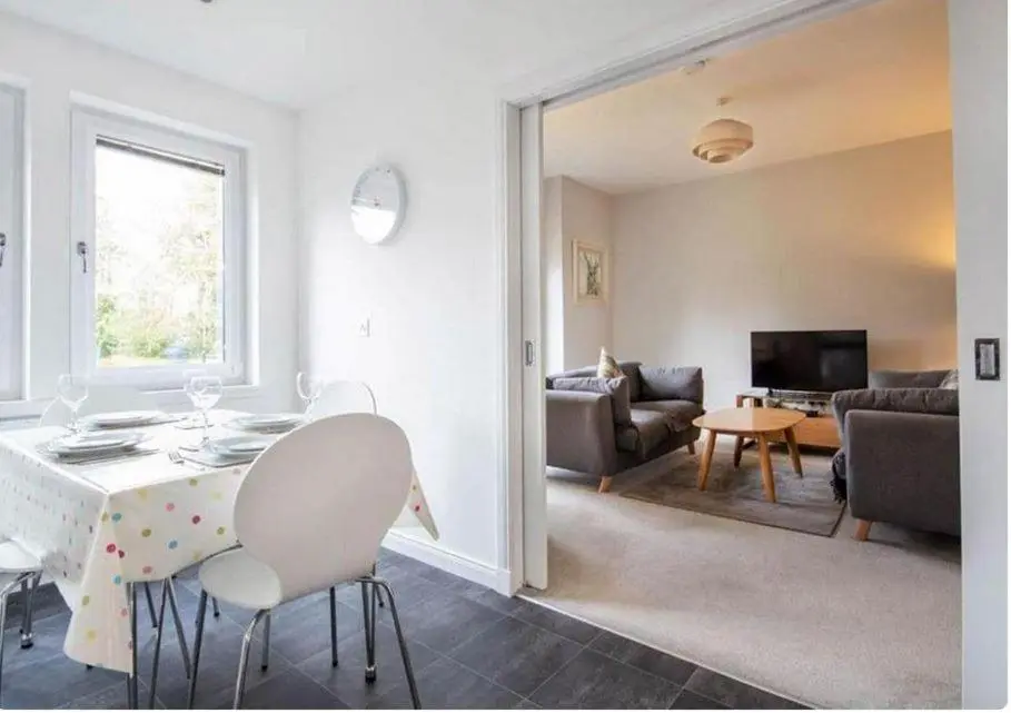 a living room with a table and chairs and a living room at 2 Bedroom Hedgefield Apartment 41-Free Parking in Inverness