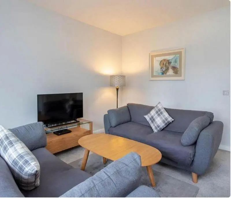 a living room with two couches and a tv at 2 Bedroom Hedgefield Apartment 41-Free Parking in Inverness