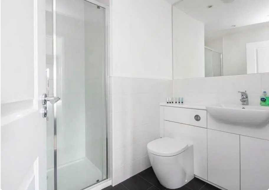 a white bathroom with a toilet and a sink at 2 Bedroom Hedgefield Apartment 41-Free Parking in Inverness