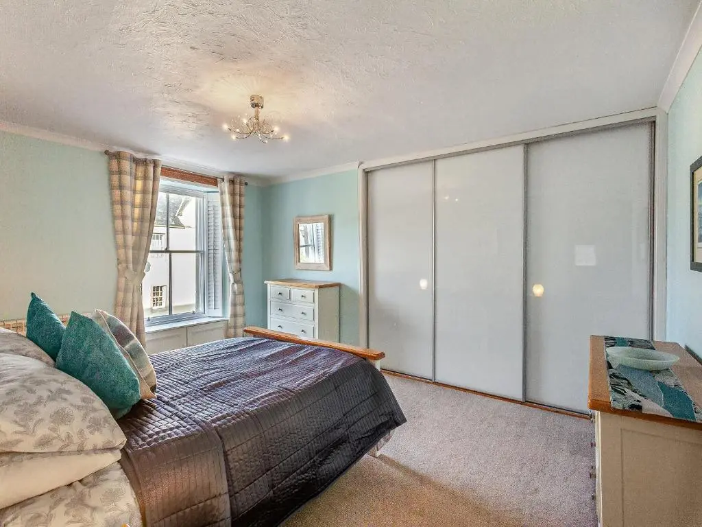 a bedroom with a large bed and a window at Ord Cottage in Kildary