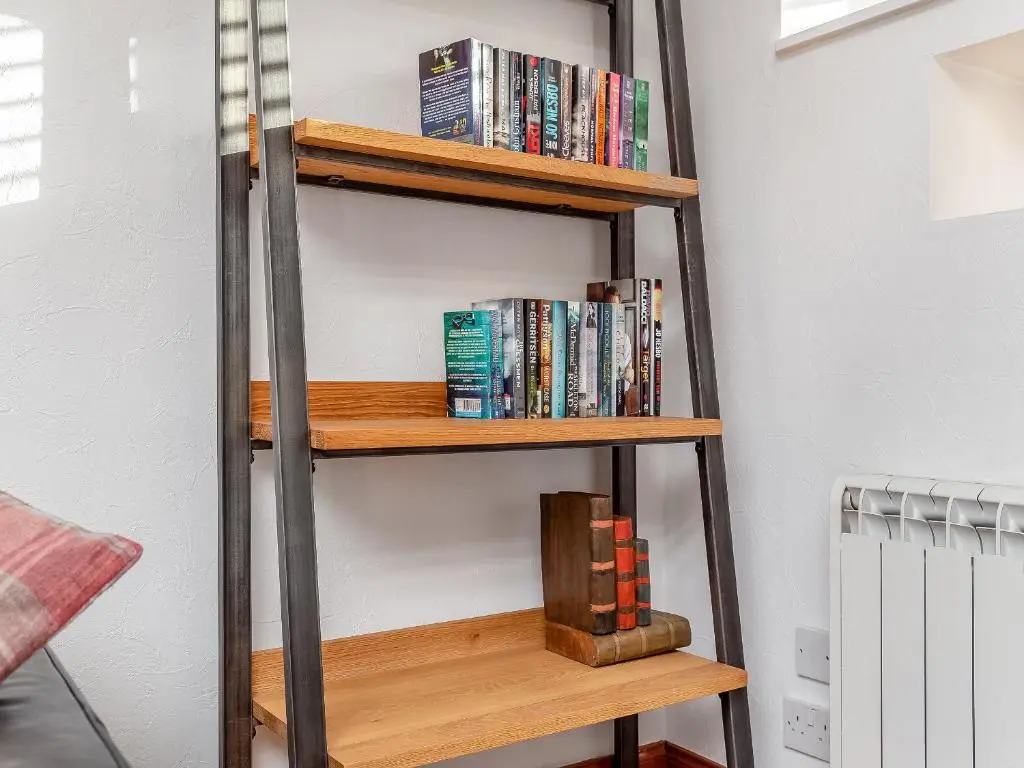 a book shelf filled with books in a room at Ord Cottage in Kildary