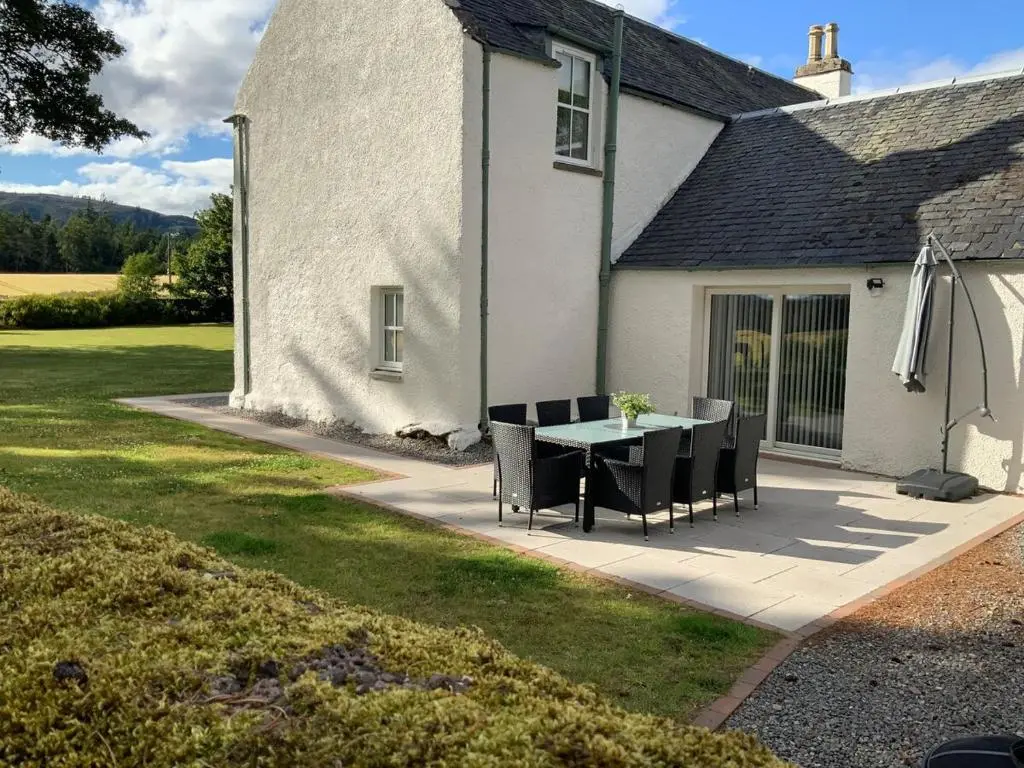 a patio with a table and chairs in front of a house at 3 Bed House near Loch Ness in Inverness