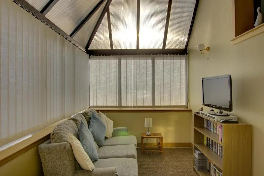 a living room with a couch and a tv at Kavija, Invergordon in Invergordon