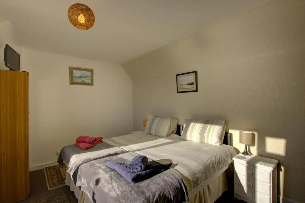 a bedroom with a bed with towels on it at Kavija, Invergordon in Invergordon