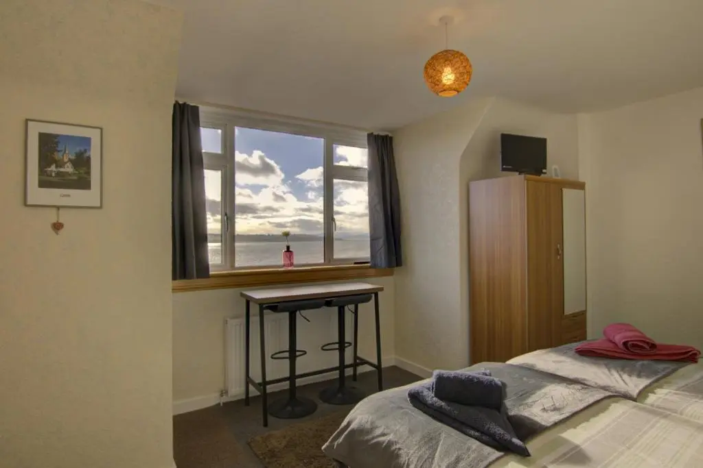a bedroom with a bed and a desk and a window at Kavija, Invergordon in Invergordon