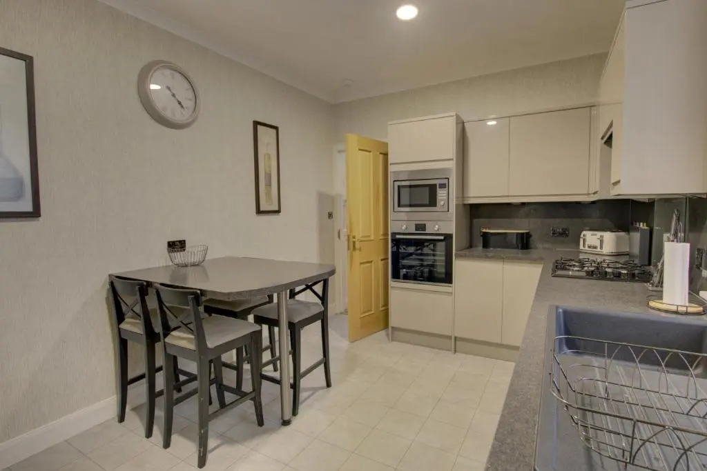 a kitchen with a table and a clock on the wall at The Clachan, Wick in Wick