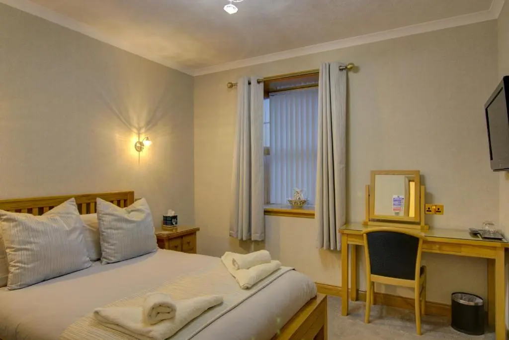 a bedroom with a bed and a desk and a computer at The Clachan, Wick in Wick