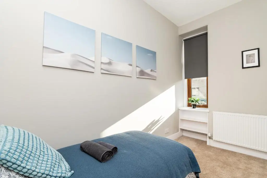 a bedroom with a blue bed and a window at 2 Bedroom Flat - Free Parking - by Holiday Homes in Inverurie