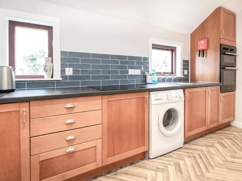 a kitchen with a washer and a washing machine at Auld House in Brora