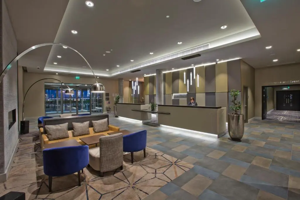 a lobby with a couch and a table and chairs at Crowne Plaza Aberdeen Airport by IHG in Dyce