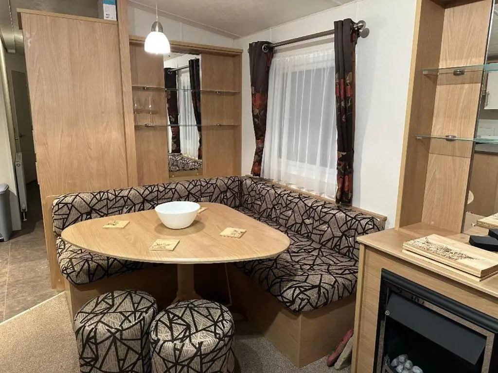 a living room with a table and a couch at Covesea View Silver Sands in Lossiemouth
