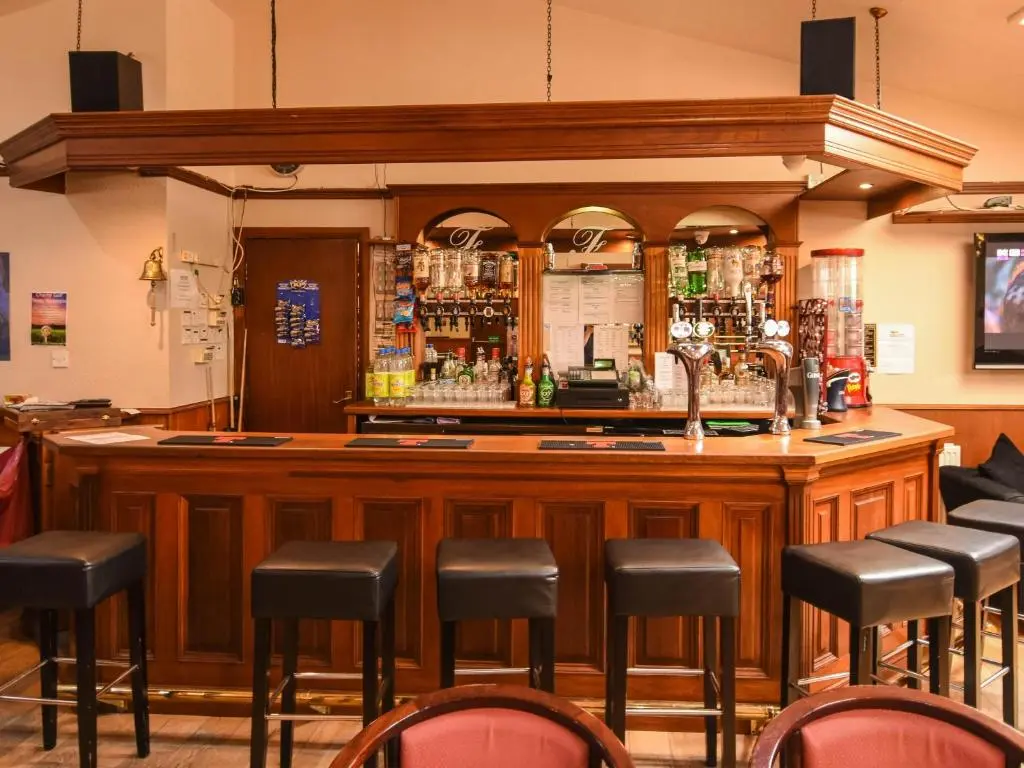 a bar with stools in a room at Findlay's in Fraserburgh