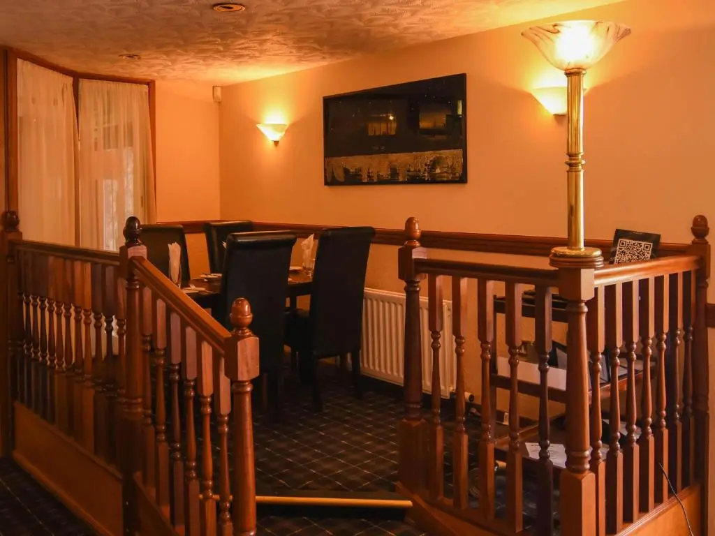 a room with a staircase with chairs and a table at Findlay's in Fraserburgh
