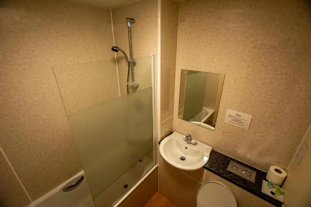 a bathroom with a sink and a toilet and a mirror at Findlay's in Fraserburgh