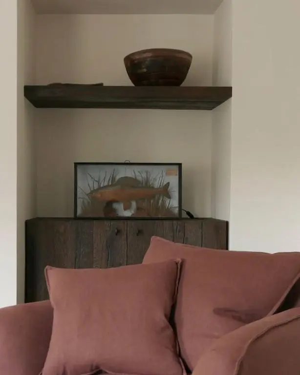 a shelf above a couch in a living room at Old school - Charming Historic Cottage for Seven in Ballater
