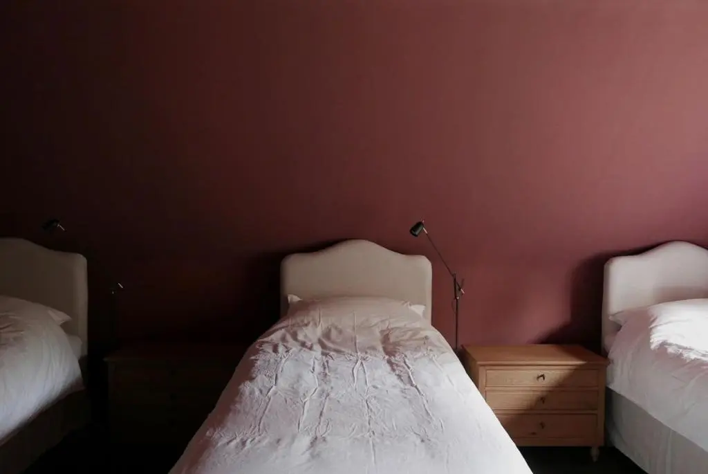 a bedroom with two beds and a lamp on a table at Old school - Charming Historic Cottage for Seven in Ballater