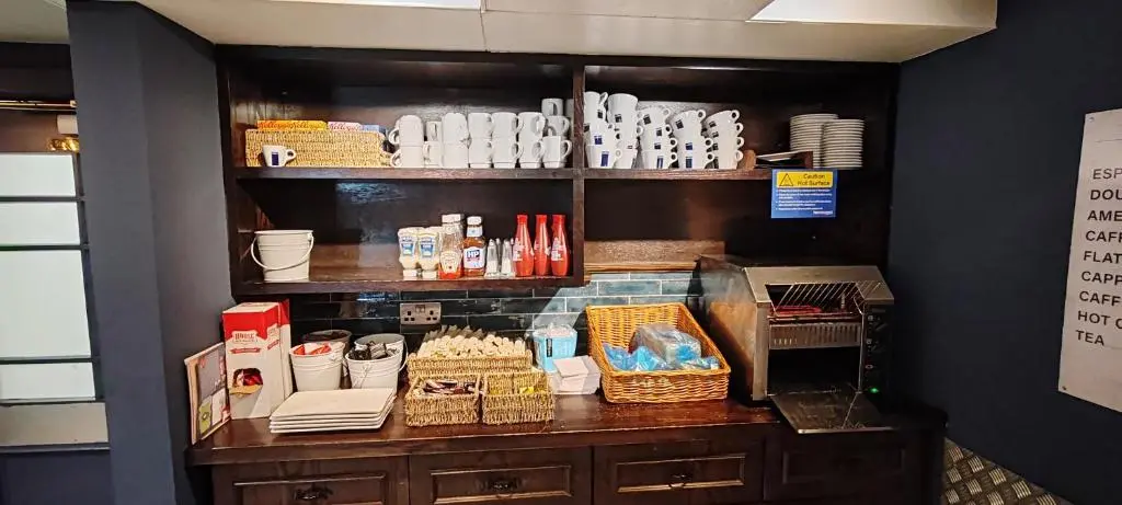 a counter with baskets and dishes on a shelf at Eagle's Den Caravan Holiday Retreat in Lossiemouth