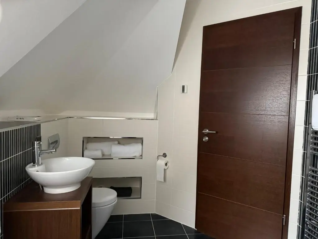 a bathroom with a sink and a toilet and a door at Castlefield Penthouse in Inverness