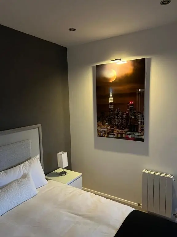 a bedroom with a bed and a picture of a city at Castlefield Penthouse in Inverness
