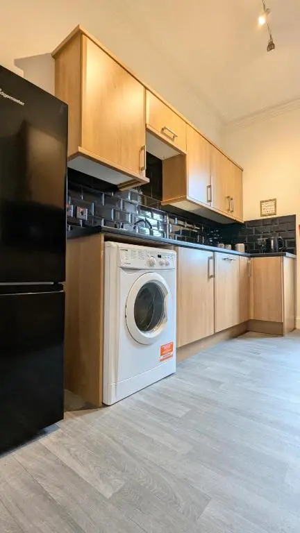a large kitchen with a washing machine in it at The Wee Heilan' Dram in Keith