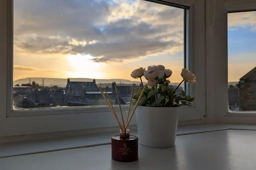 a vase with flowers sitting on a window sill at The Wee Heilan' Dram in Keith