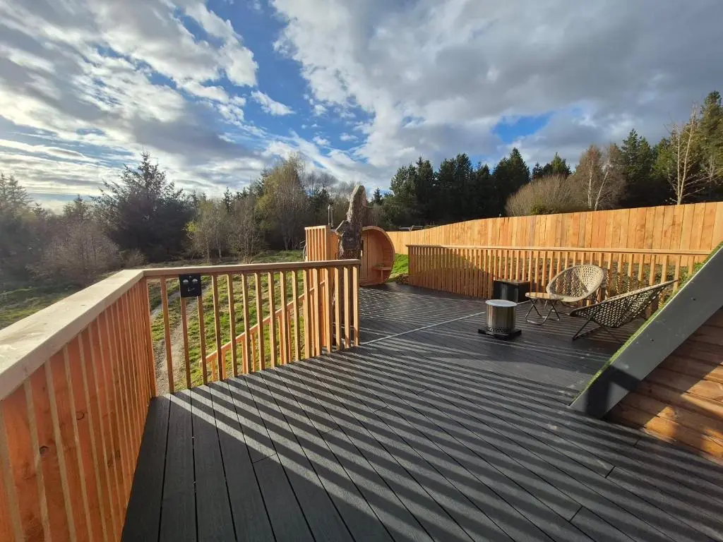 a wooden deck with a bench and a fence at Little Getaway in the Highlands, private sauna and stargazing geodome in Garve