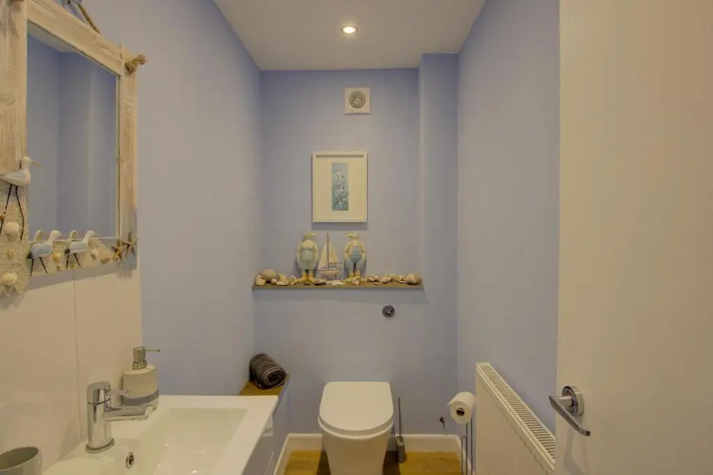 a bathroom with a white toilet and a sink at Beach Croft, Brora in Brora