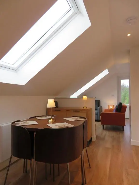 a skylight in a living room with a table and chairs at The Loft at Log Ness in Inverness