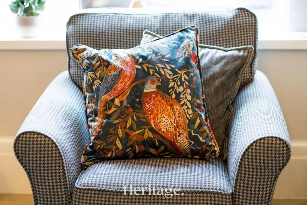 a pillow on a chair in a living room at The Copper Loft Apartment, Keith in Keith