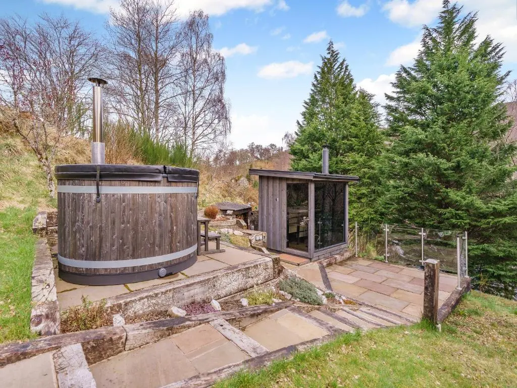 a hot tub and a gazebo in a yard at Clunie Dam Lodge in Blair Atholl