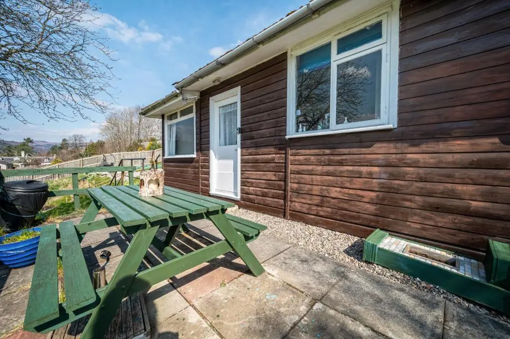 a picnic table outside of a tiny house at 2 Bed Chalet - Sleeps 4 - River and mountain views in Strathpeffer
