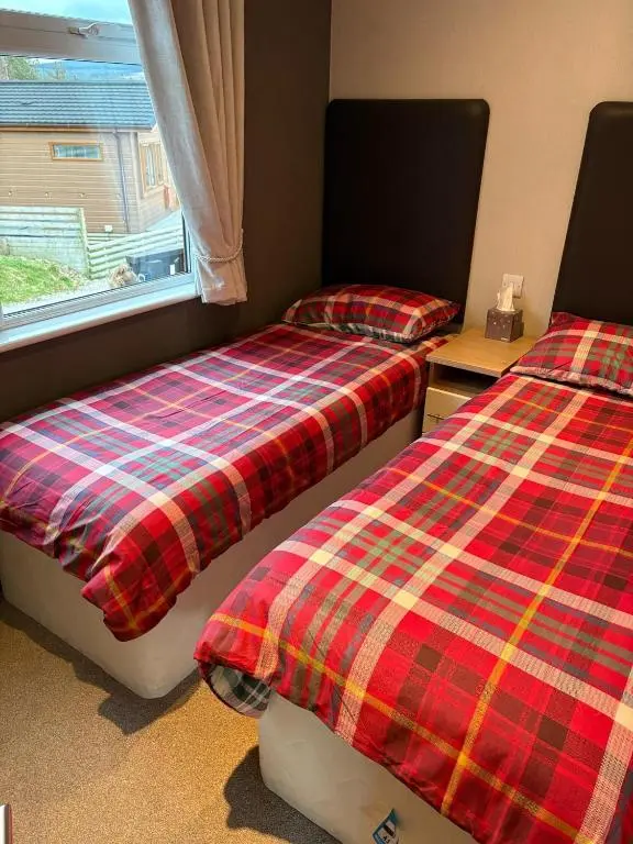 two beds sitting next to each other in a room at Hepburns Lodge 19 in Strachan