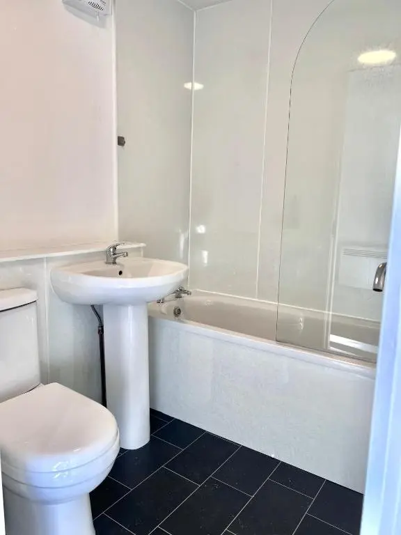 a bathroom with a sink and a toilet and a tub at Elegant Apartment In City Centre in Inverness