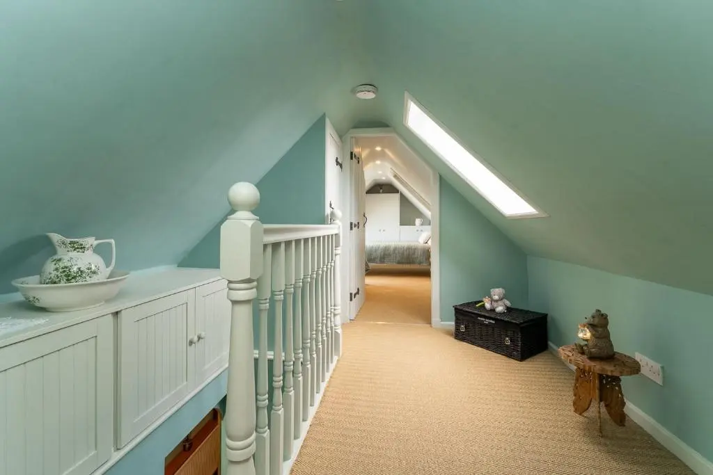a hallway with blue walls and a staircase in a house at Fishermans Cottage in Lossiemouth