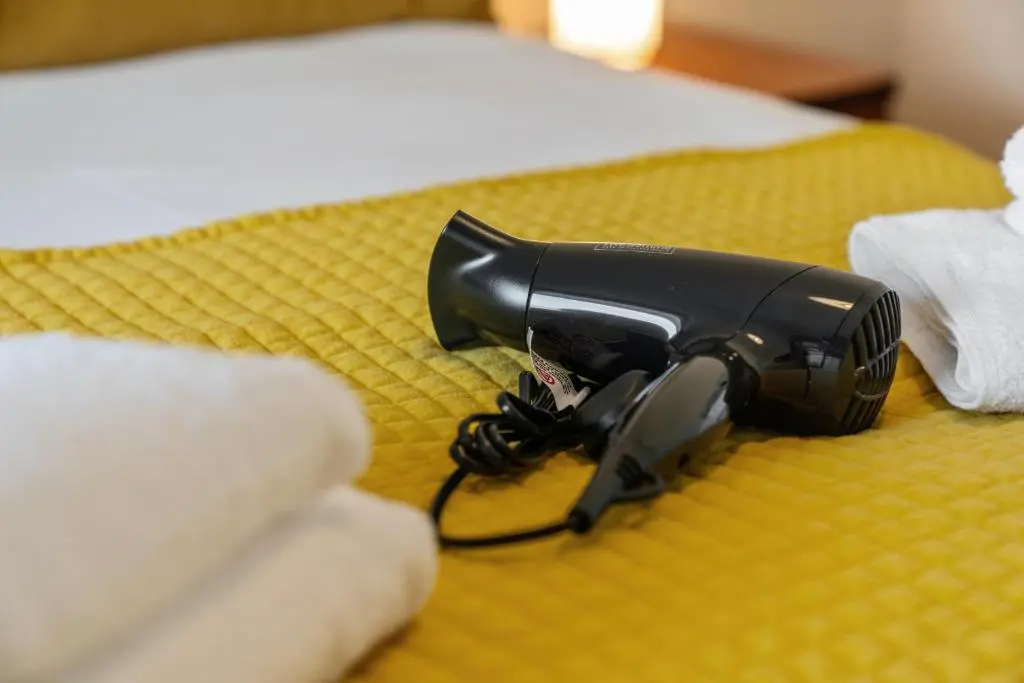 a blow dryer sitting on a bed with towels at Central 1 Bedroom Apartment - Inverness in Inverness