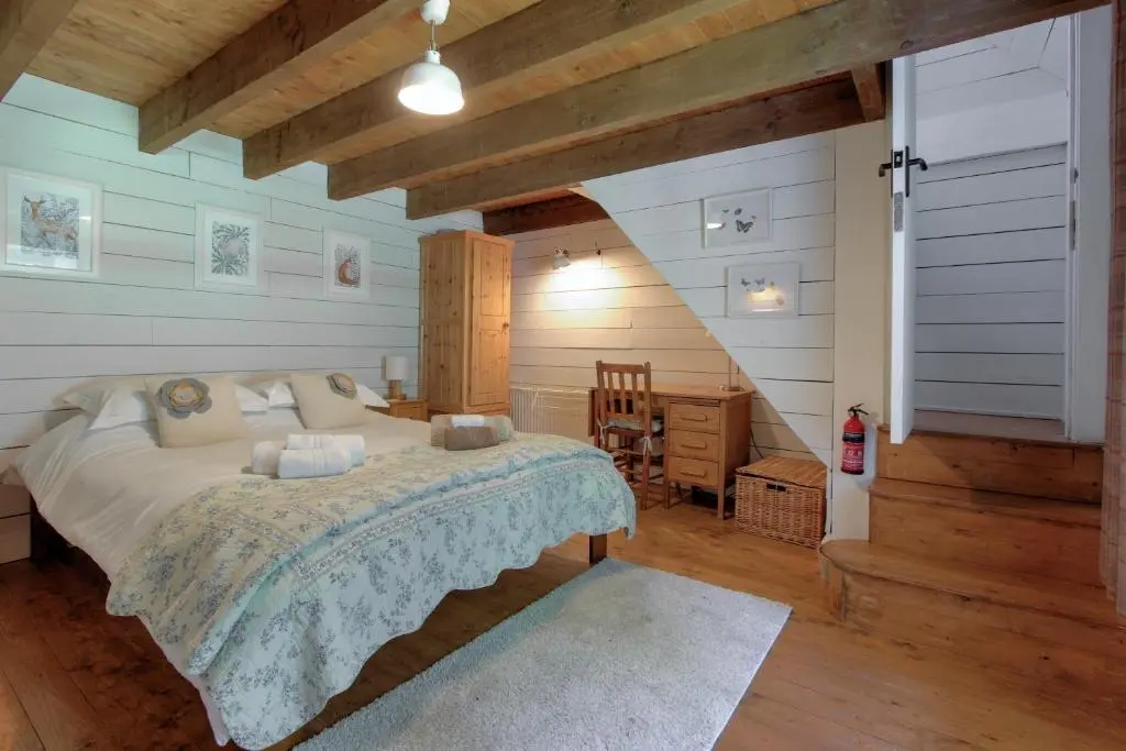 a bedroom with a large bed in a attic at Bridge Cottage in Glenlivet