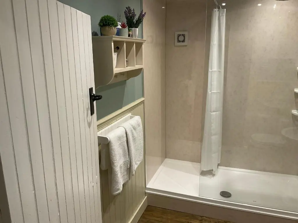 a bathroom with a shower and a towel at Bridge Cottage in Glenlivet