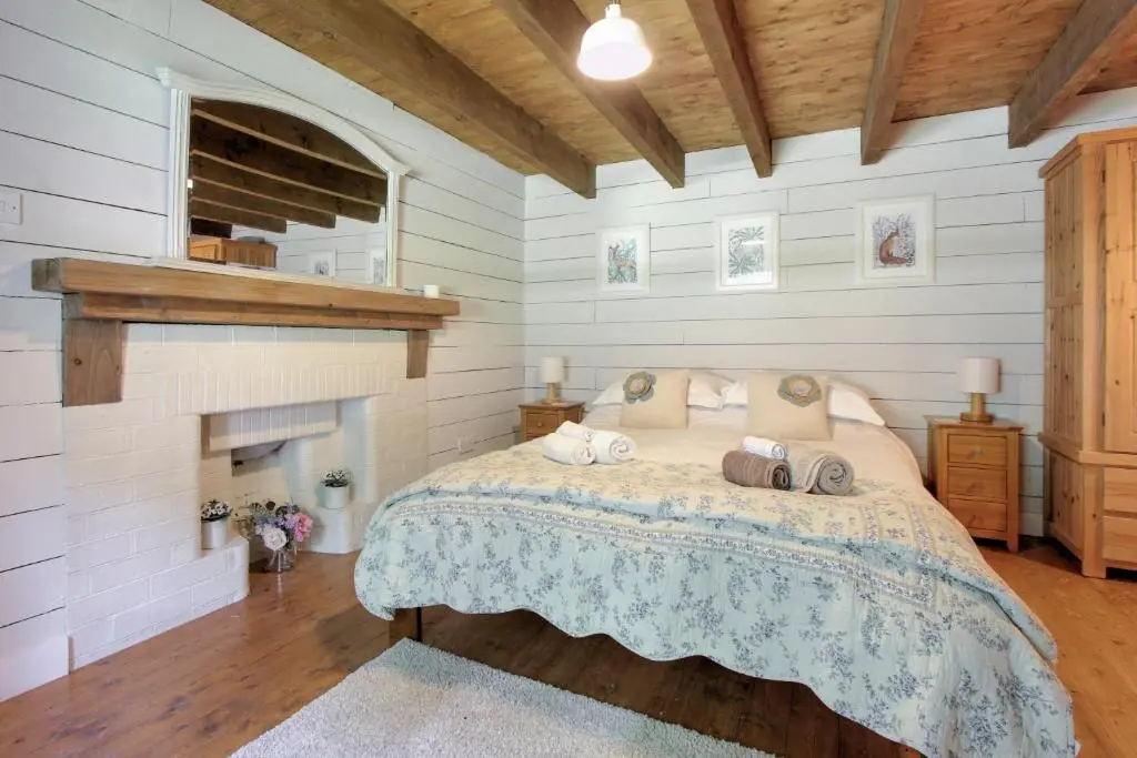 a bedroom with a bed and a fireplace at Bridge Cottage in Glenlivet