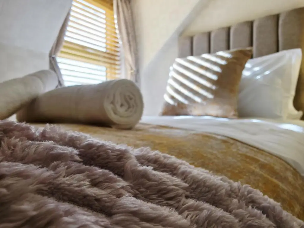 a bed with a brown blanket and pillows on it at Inverness City 4 Bedroom house free parking in Inverness
