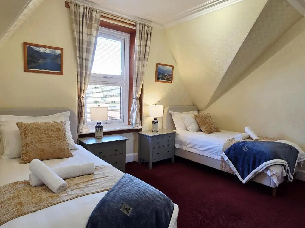 a bedroom with two beds and a window at Inverness City 4 Bedroom house free parking in Inverness