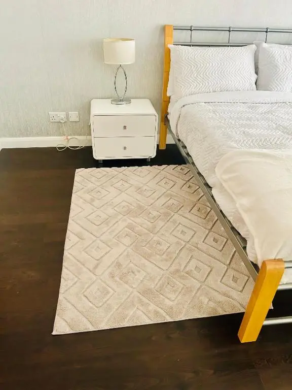 a bedroom with a bed and a night stand with a lamp at Luxury 2 bedroom apartment in Aberdeen in Kirkton of Skene