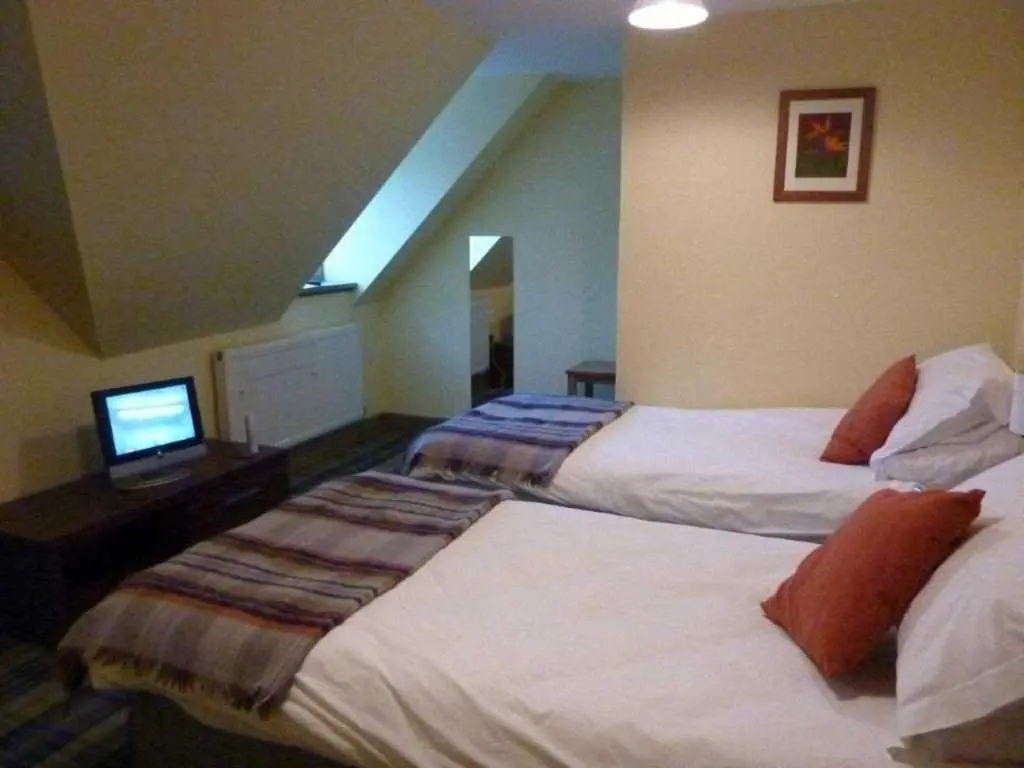 a hotel room with two beds and a television at Moat House - Highland Club in Fort Augustus