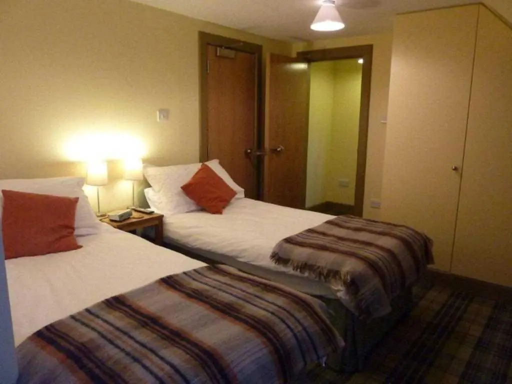 two beds sitting next to each other in a hotel room at Moat House - Highland Club in Fort Augustus