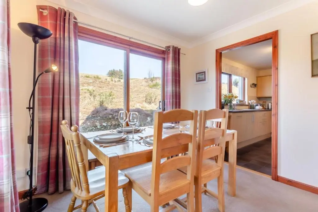 a dining room with a table and chairs and a window at 3 Bed in Strathkanaird oc-r30948 in Ullapool