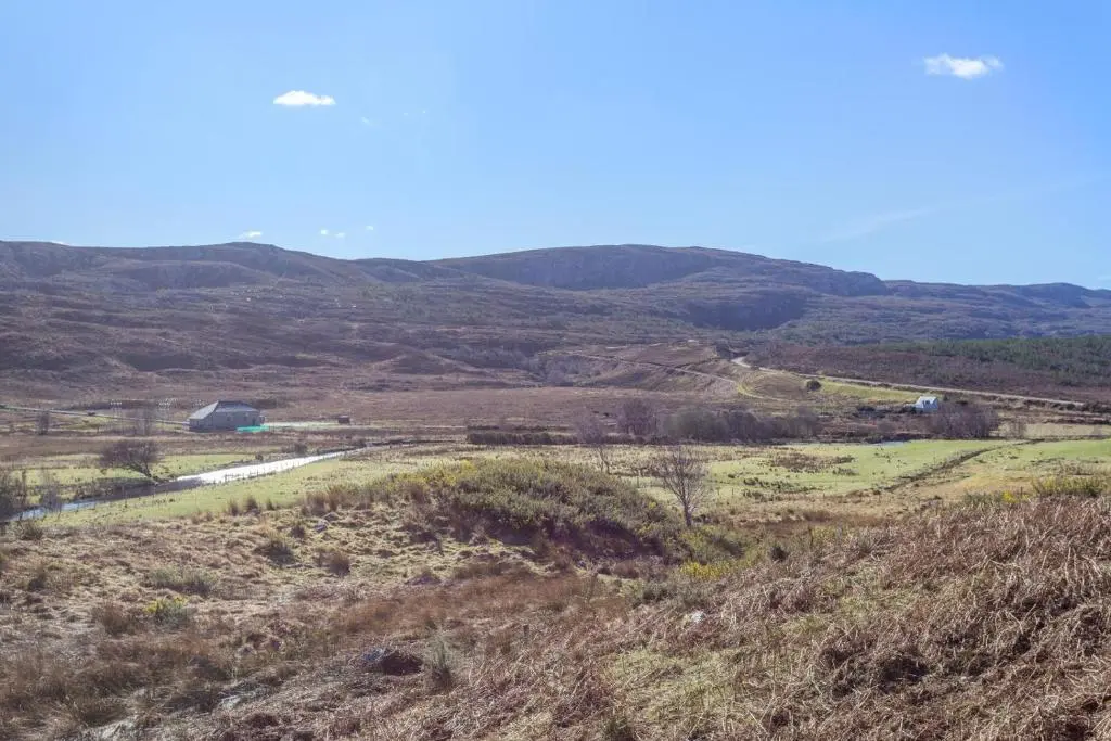 a view of a field with hills in the background at 3 Bed in Strathkanaird oc-r30948 in Ullapool
