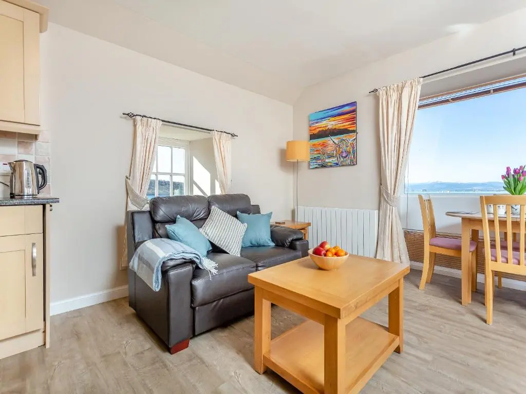 a living room with a couch and a table at Harbour View in Cromarty