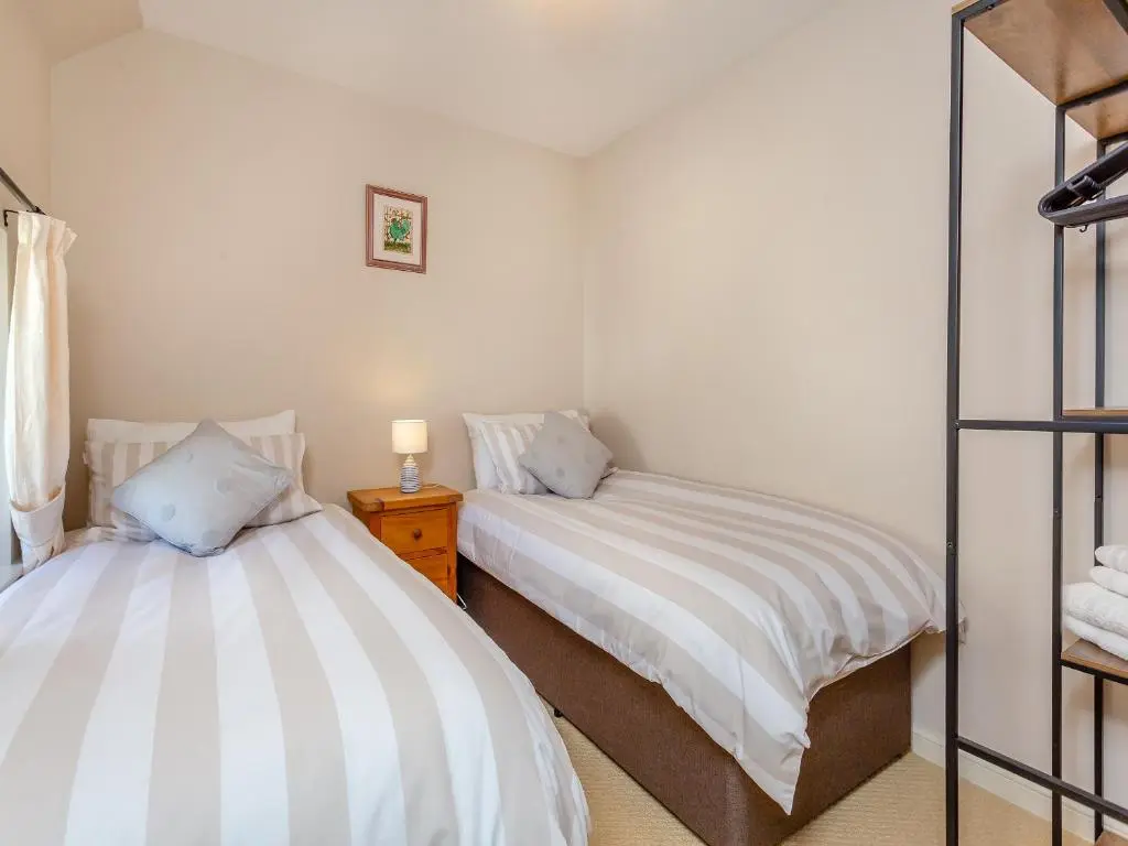 a bedroom with two beds and a mirror at Harbour View in Cromarty