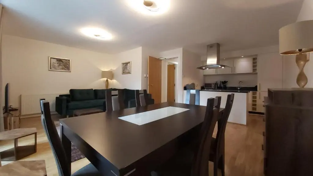 a dining room and living room with a table and chairs at Highland Club Scotland Apartments in Fort Augustus