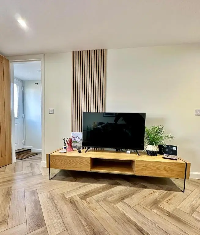 a living room with a flat screen tv on a table at Cozy Cottage Retreat in Portsoy